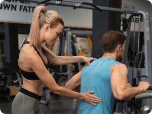 trainer-helping-beginner-gym-rounded